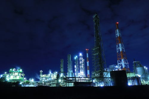 工場夜景と立ち並ぶ鉄塔の写真