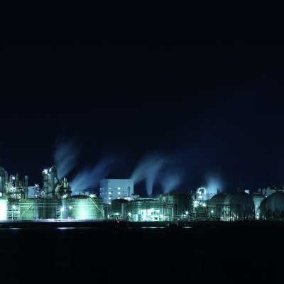 暗闇に浮かぶ工場夜景の丸タンクの写真