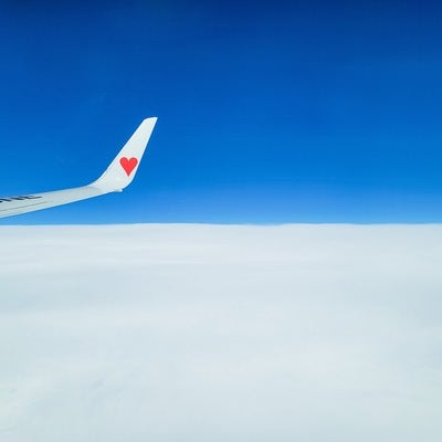雲の上で飛行機の翼の写真
