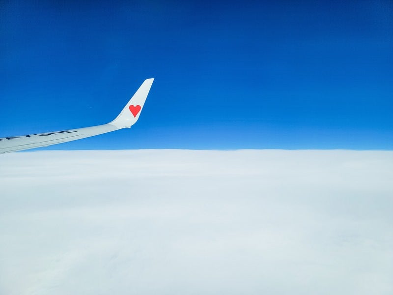 雲の上で飛行機の翼の写真