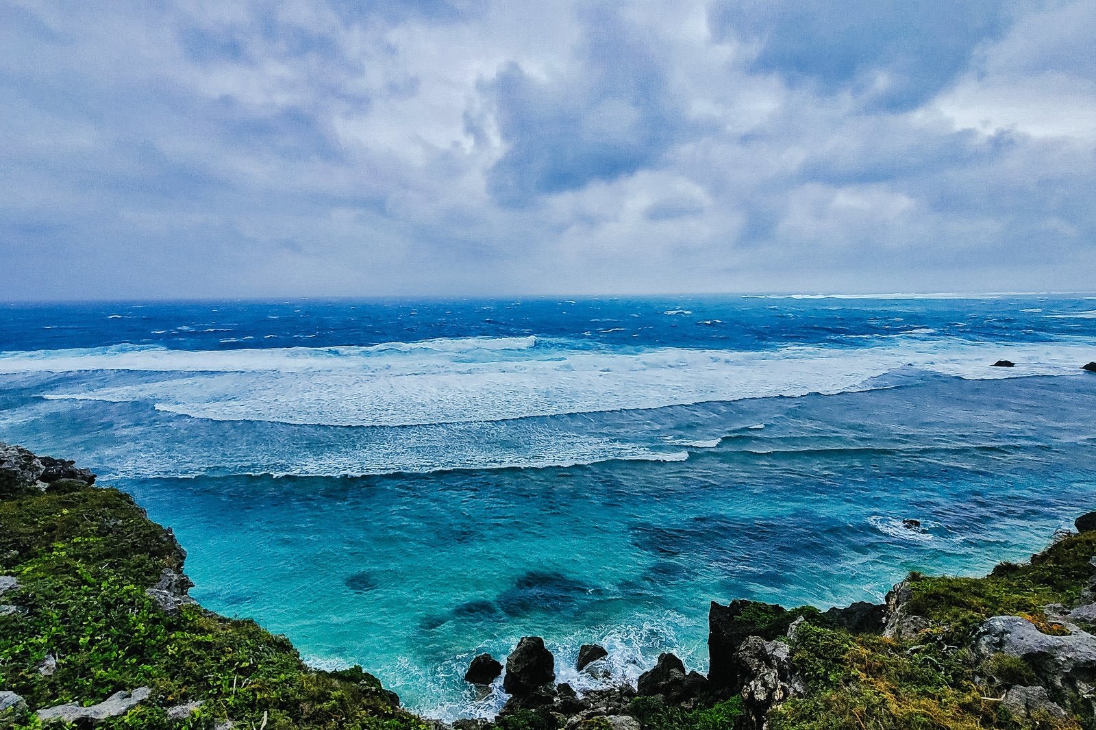 宮古島の海岸から見たエメラルドグリーンの海と複数の波