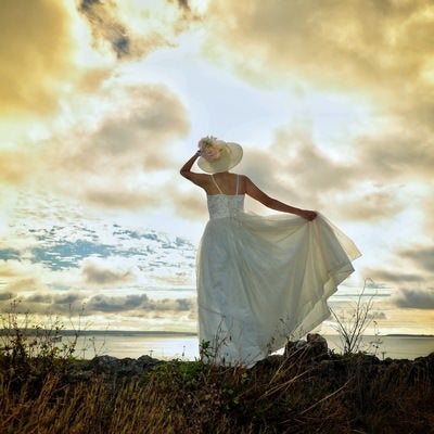 海に向かう白いドレスの女性の写真