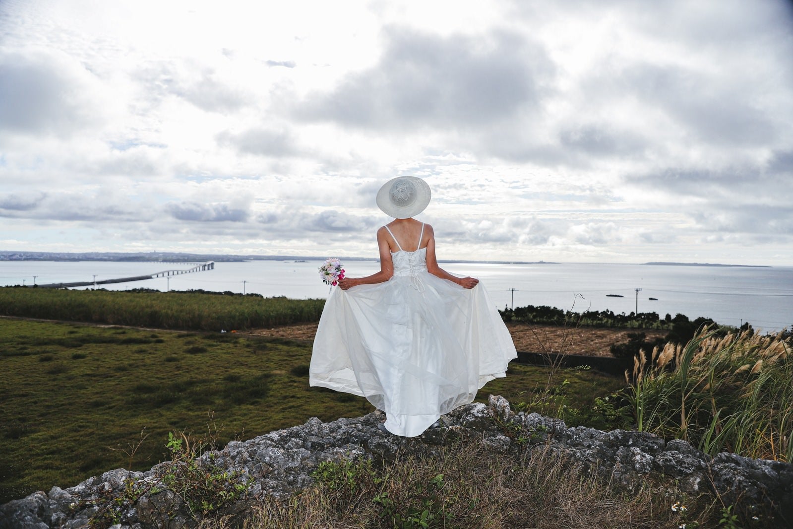 「海を見下ろすウェディングドレスの女性」の写真［モデル：モデルリリース］