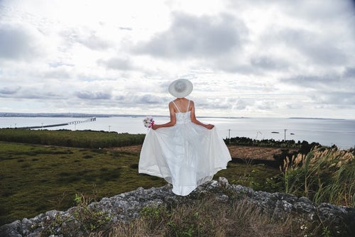 海を見下ろすウェディングドレスの女性の写真