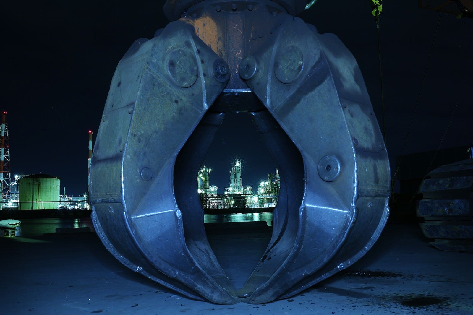 「巨大なキャッチャーと奥の工場夜景」の写真