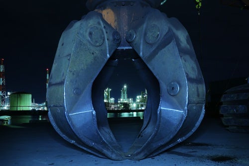 巨大なキャッチャーと奥の工場夜景の写真