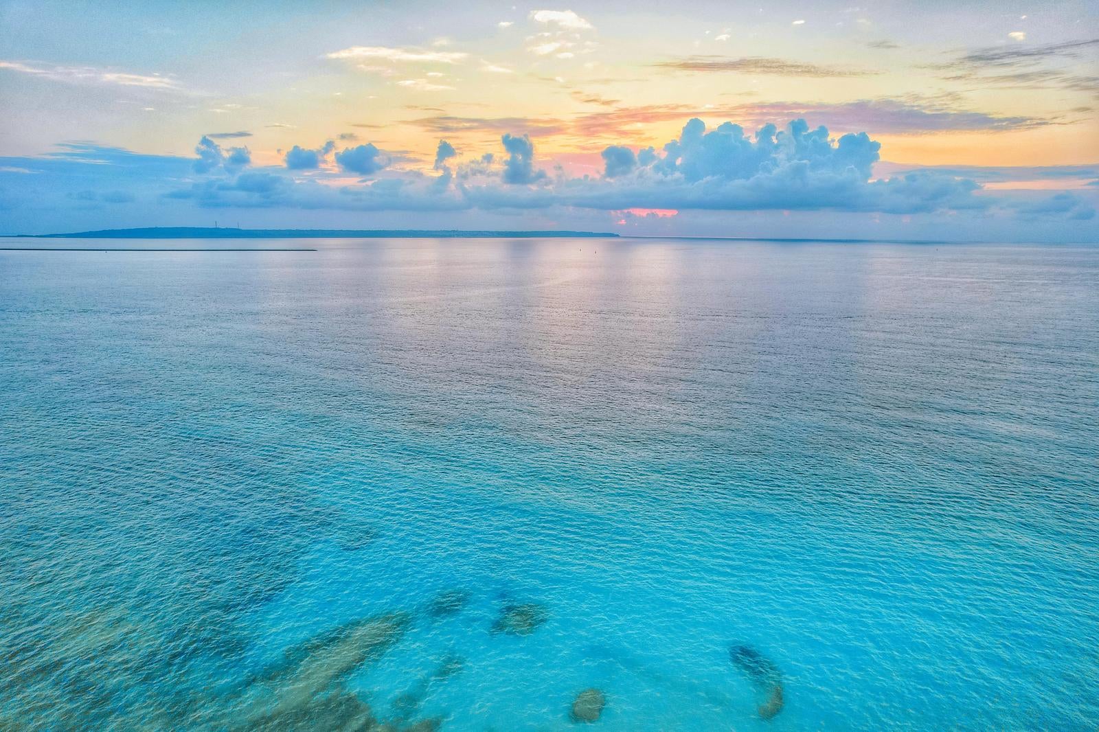 「日暮れのオレンジの空と静かな宮古島の海」の写真