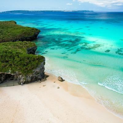 碧く澄む海と白い砂浜の写真