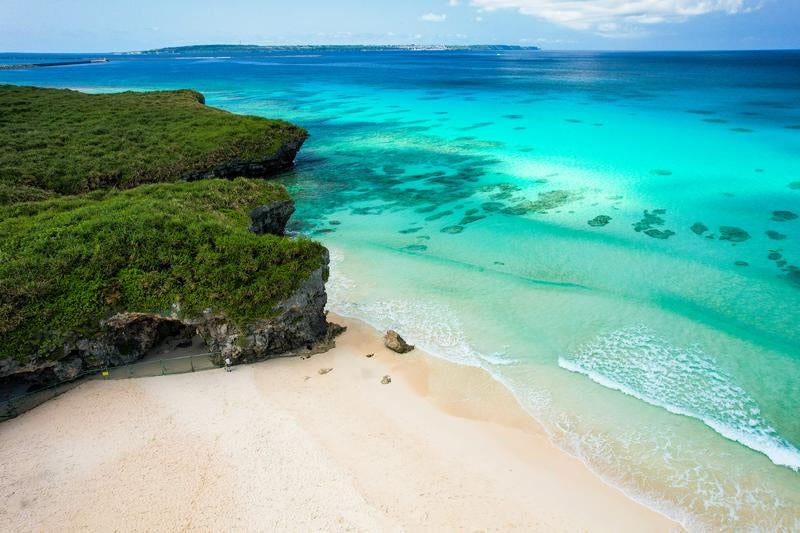 碧く澄む海と白い砂浜の写真