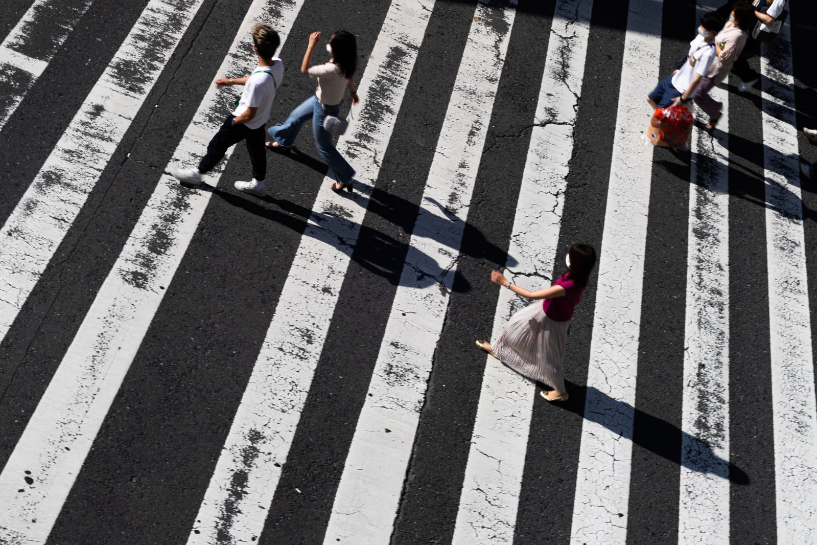 「横断歩道の歩行者と影」の写真