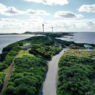 風車が並ぶ西平安名崎と宮古島の青い海の写真