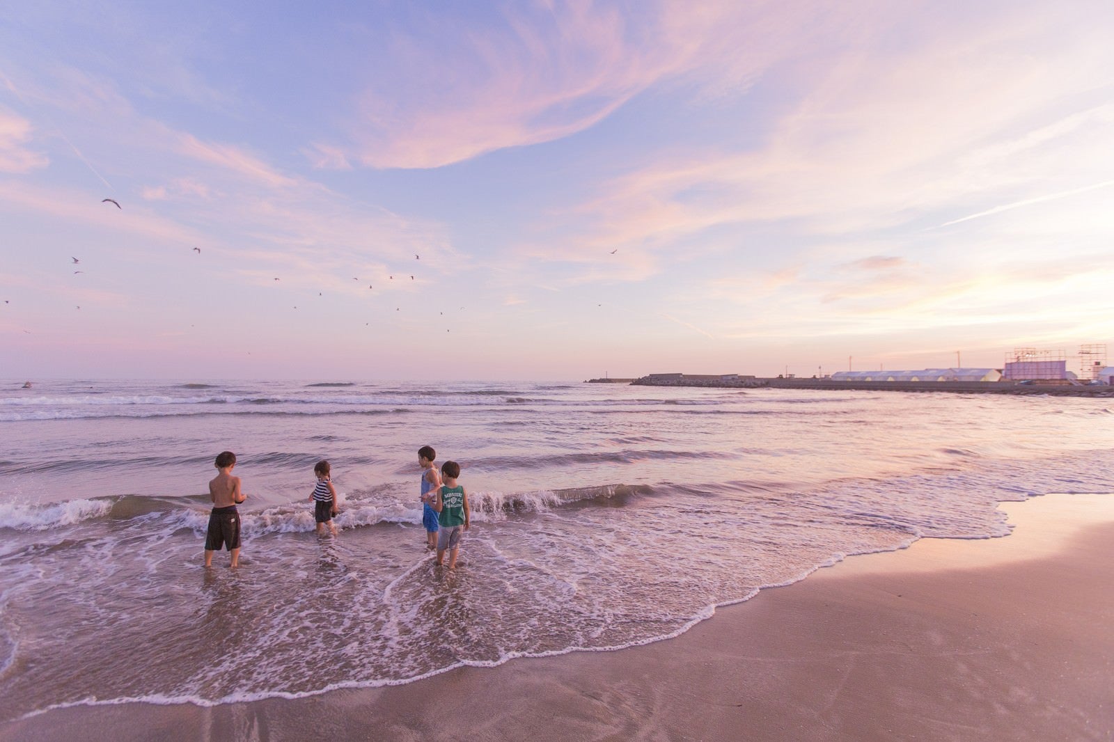 「夕暮れに浜辺で遊ぶ子どもたち」の写真