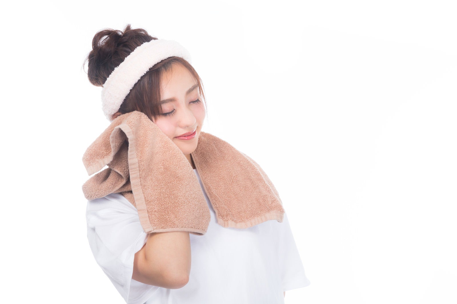 「タオルで頬を覆う女性」の写真［モデル：河村友歌］
