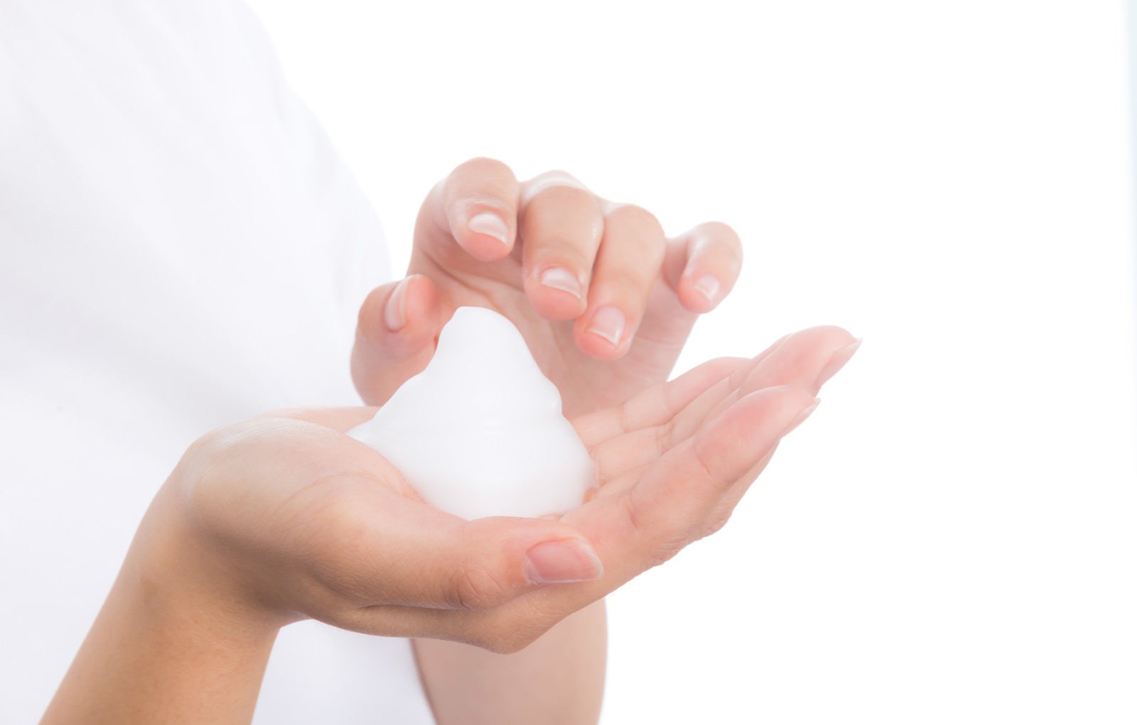 「クレンジング用の泡を持つ女性の手」の写真