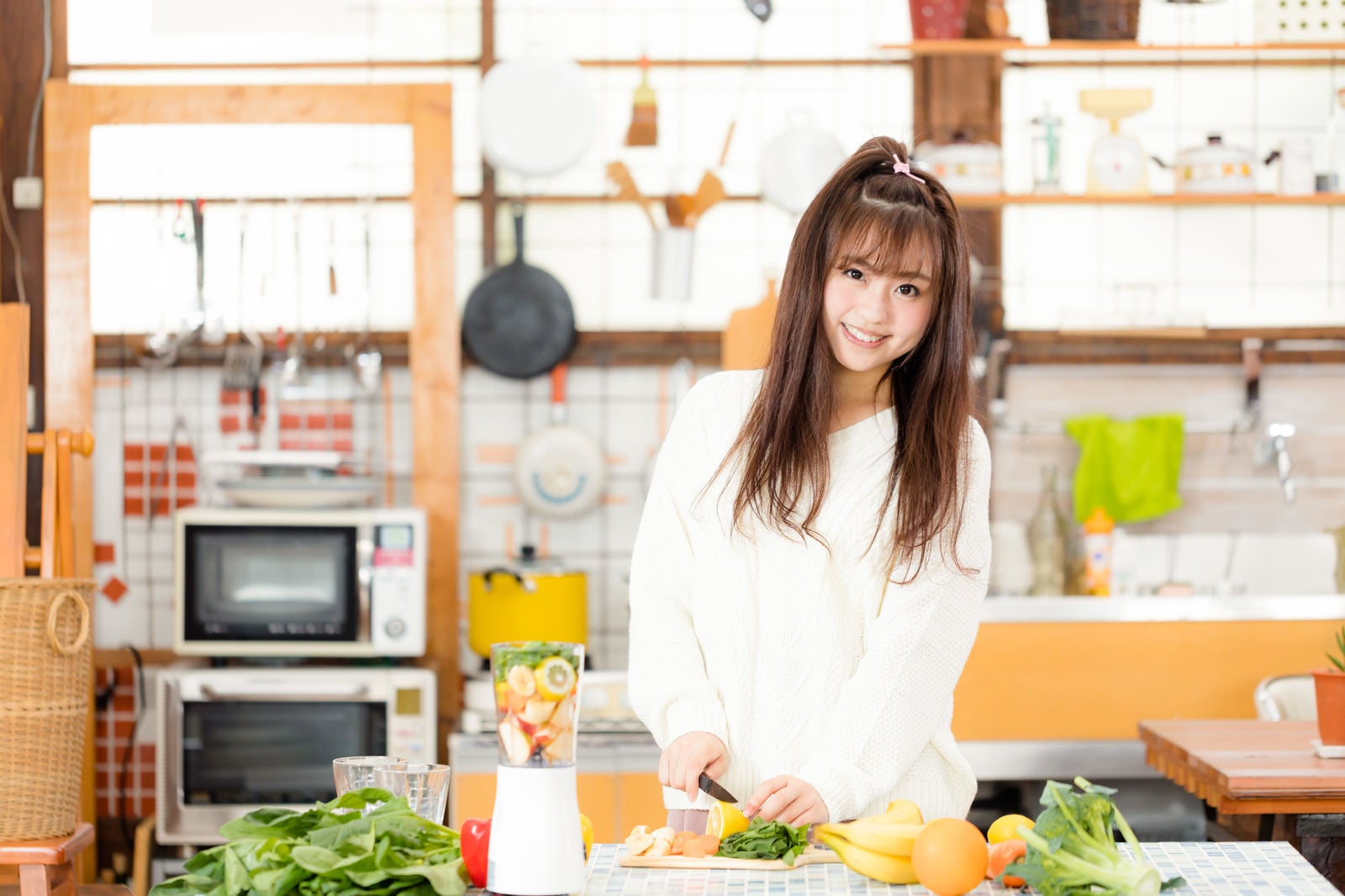 「キッチンで朝スムージーを作る女子」の写真［モデル：河村友歌］