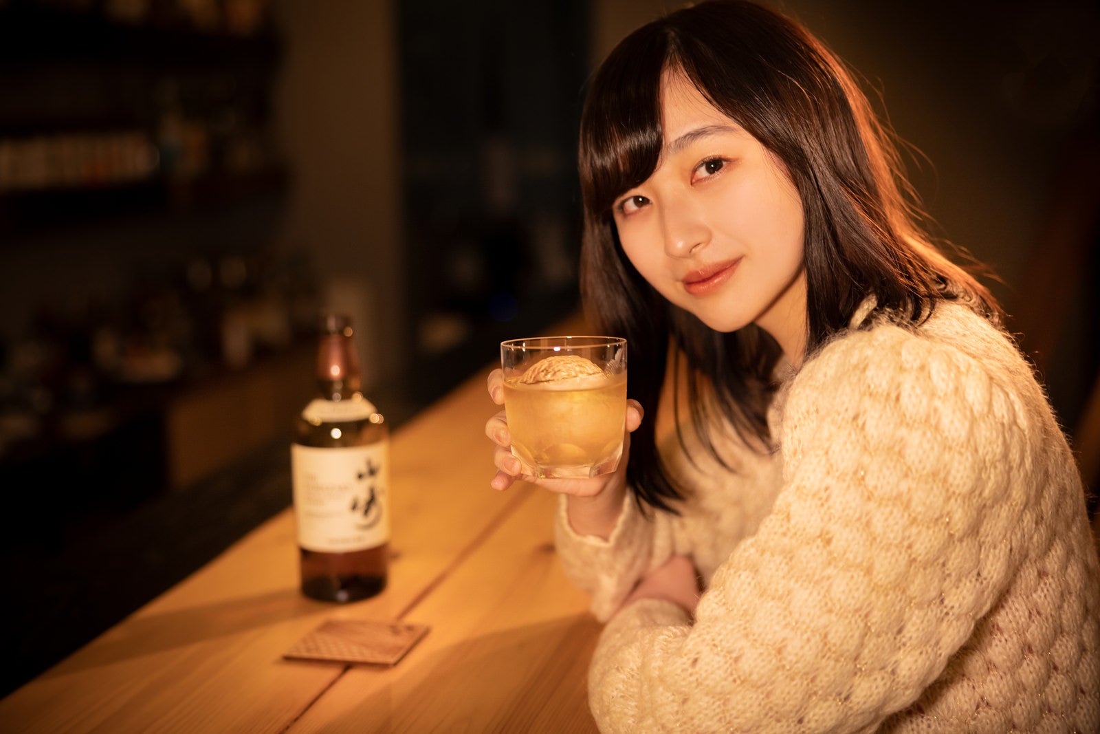 「BARのカウンターで女性とウイスキーで乾杯」の写真［モデル：井隼そら］