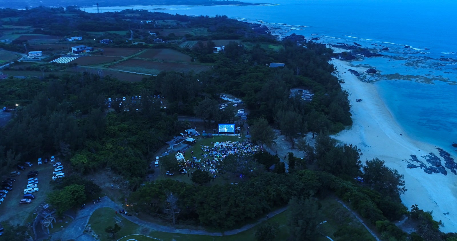 「映画館の無い徳之島で野外シネマのイベント（空撮）」の写真