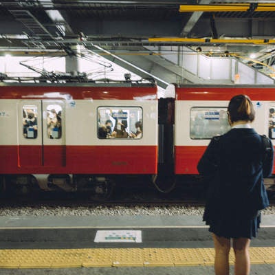 京急線ホームに並ぶ学生の写真