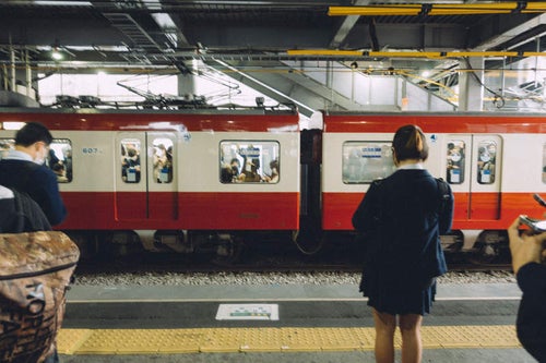 京急線ホームに並ぶ学生の写真
