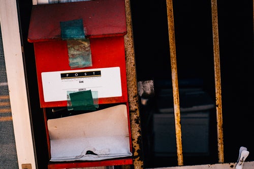 無人の家屋と赤い郵便受けの写真