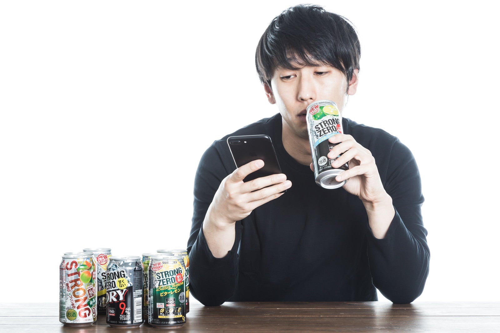 「缶チューハイを飲みながら廃課金するソシャゲユーザー」の写真［モデル：大川竜弥］