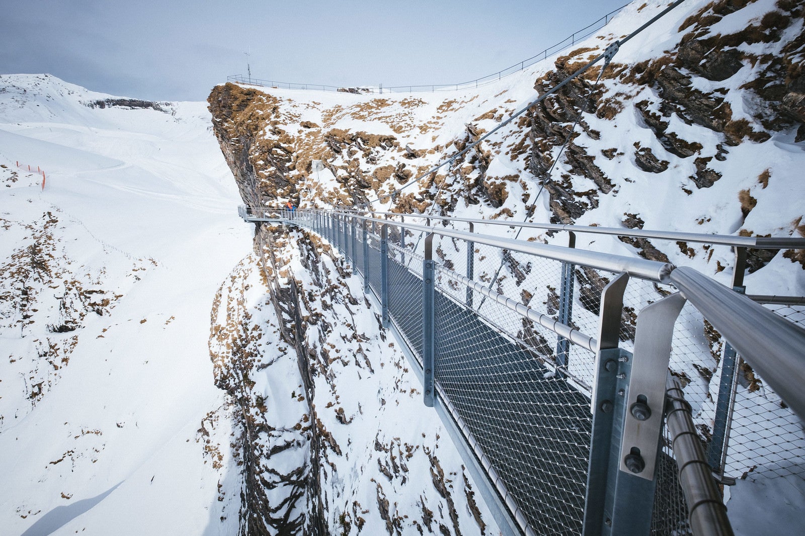 「断崖雪壁に設置された吊橋の様子（スイス）」の写真
