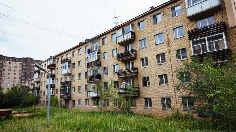 草生い茂る中庭とモンゴルの集合住宅の写真