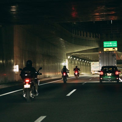 夜間走行するバイクと自動車の写真