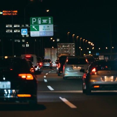 高速道路の等間隔に光るテールランプの写真