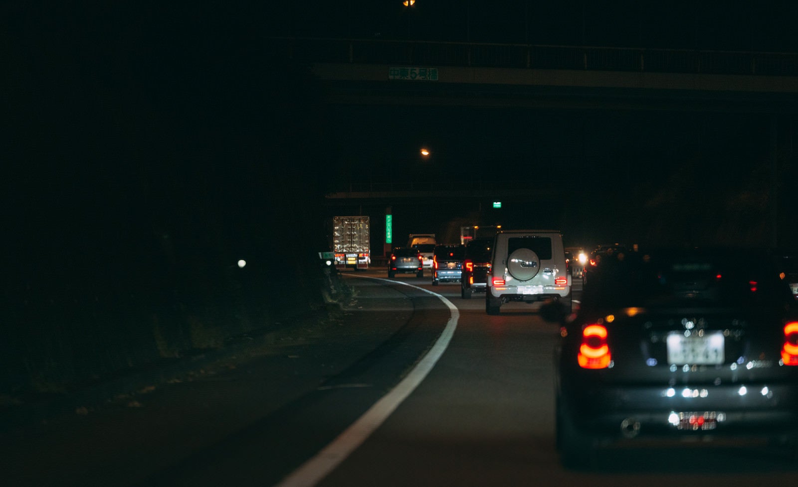 「夜の高速道路に光るテールランプ」の写真