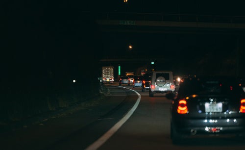 夜の高速道路に光るテールランプの写真