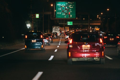 夜間渋滞に伸びる赤いテールランプの写真
