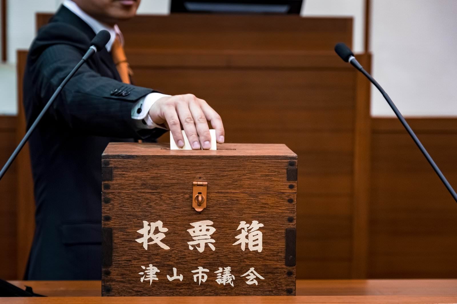 「投票箱に一票を投じる津山市議会議員」の写真