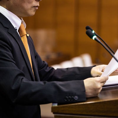 質問原稿を手に取る現職の津山市議会議員の写真
