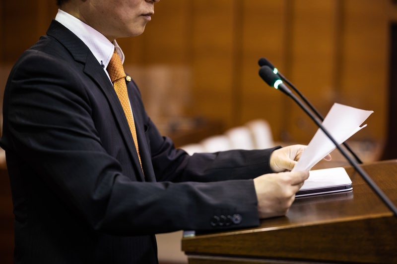質問原稿を手に取る現職の津山市議会議員の写真