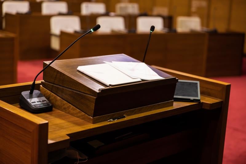 資料とマイクが並ぶ議会演壇の写真