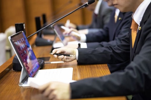 議会中タブレットを使用する議員の写真