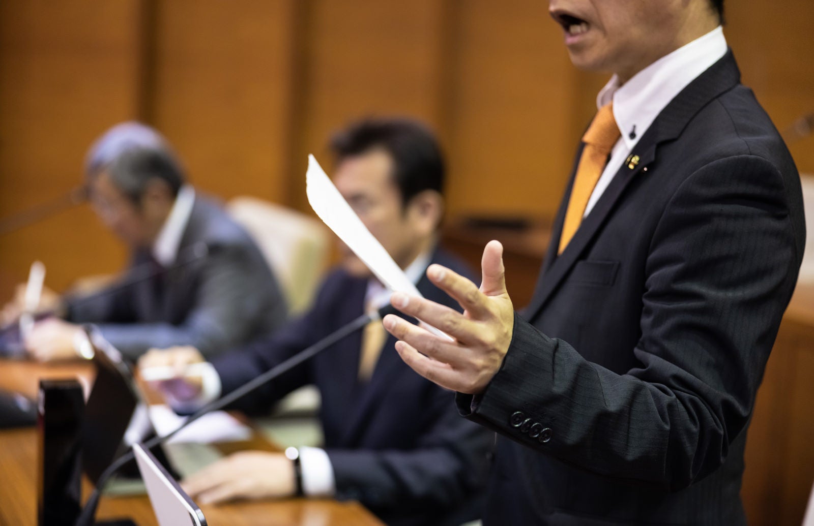 「紙資料を見ながら厳しく質す津山市議会議員」の写真