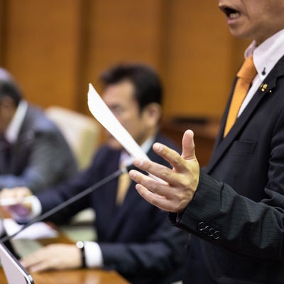 紙資料を見ながら厳しく質す津山市議会議員の写真
