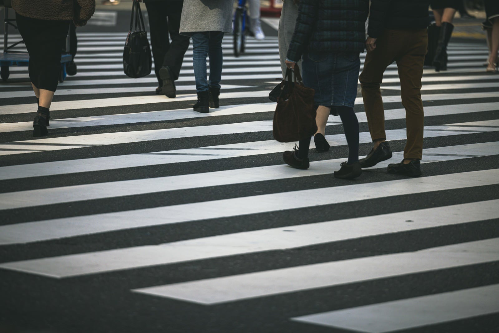 「横断歩道を渡る人の足元」の写真
