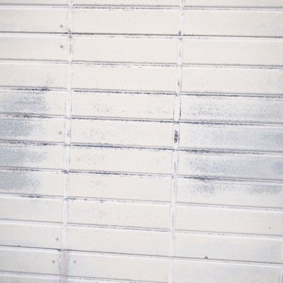 擦れ跡残るホワイト色のタイル壁（テクスチャ）の写真