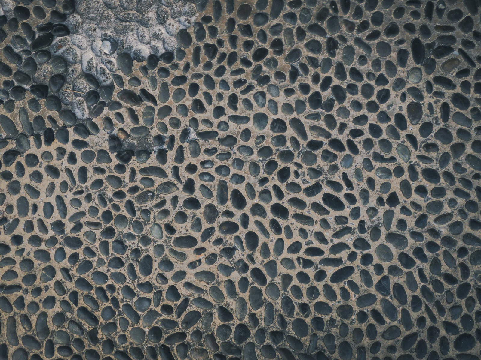 「剥がれた箇所のある小石床」の写真
