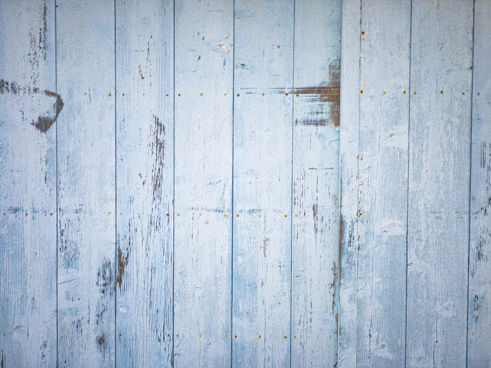 「塗装剥がれのある板壁と錆びたビスのテクスチャー」の写真