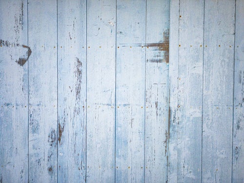 塗装剥がれのある板壁と錆びたビスのテクスチャーの写真