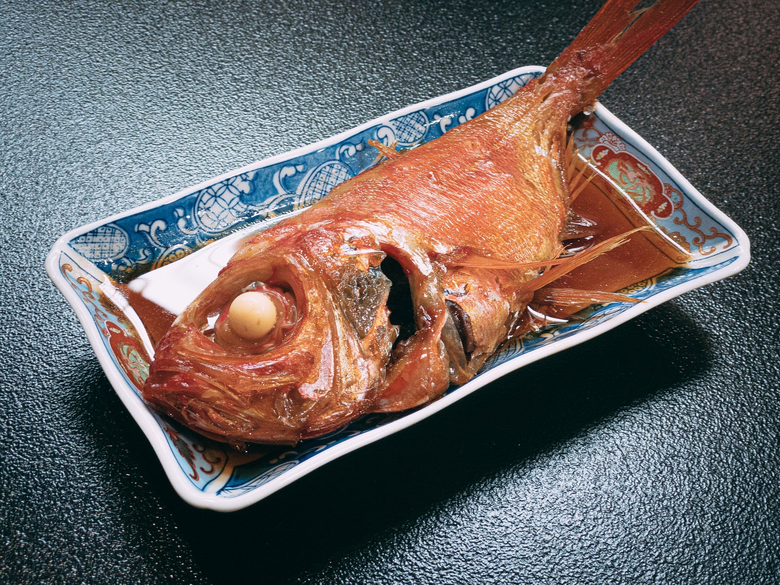 「皿に乗った金目鯛の煮付け」の写真