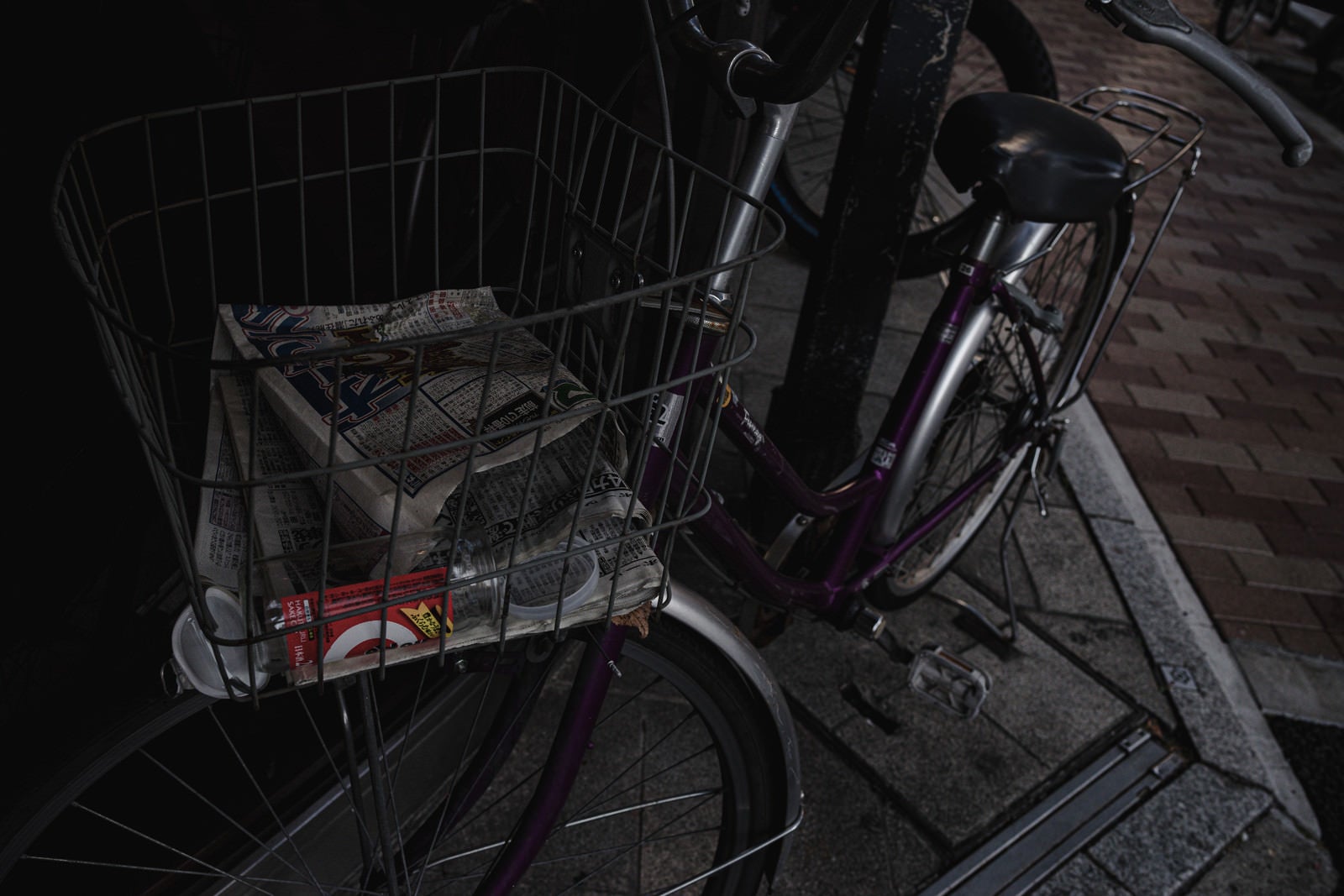 「ワイヤーバスケットにゴミが残る放置自転車」の写真