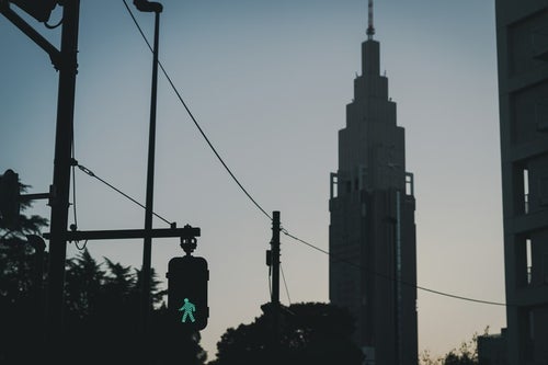 横断歩道の青信号とNTTドコモタワーのシルエットの写真
