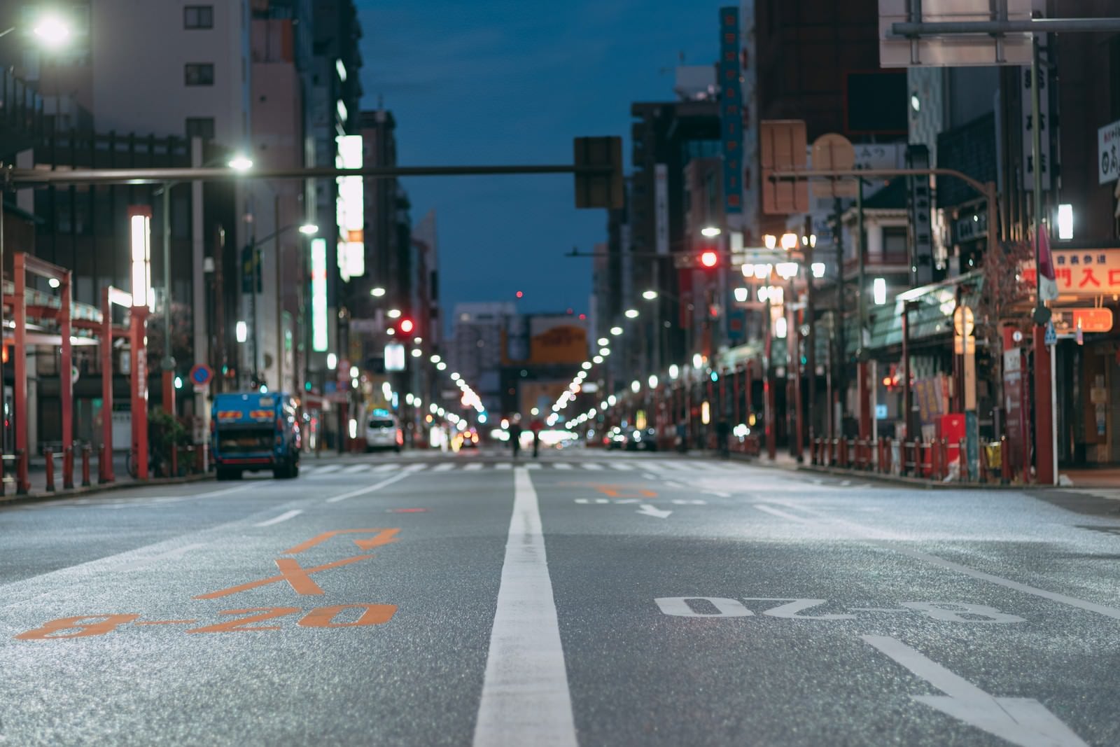「車道のセンターラインと夜の街並み」の写真