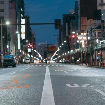 車道のセンターラインと夜の街並みの写真
