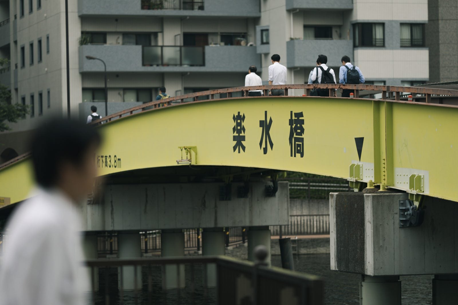 「黄色い楽水橋を渡る人たち」の写真